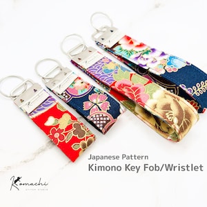 May include: Four Japanese pattern kimono key fobs/wristlets with silver key rings. The fabric features floral designs in red, blue, purple, and gold. The text "Japanese Pattern Kimono Key Fob/Wristlet" is visible.