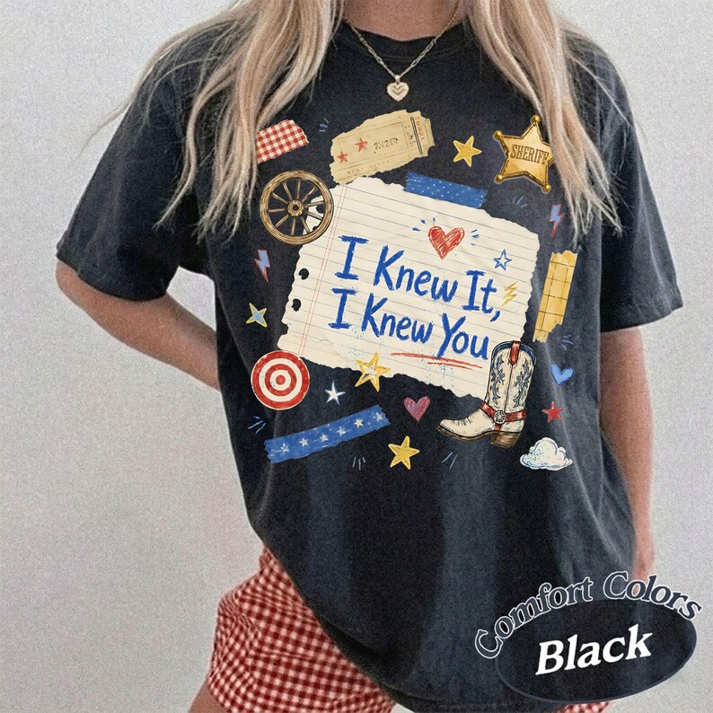 Puede incluir: Una camiseta negra de manga corta con un gr&aacute;fico central de papel de cuaderno rayado con el texto I Knew It, I Knew You. El dise&ntilde;o incluye una bota vaquera, una estrella de sheriff, una rueda de carreta, una diana y varias estrellas y corazones.