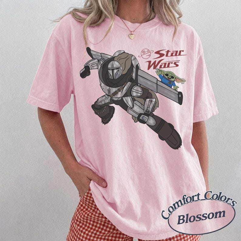 Pu&ograve; includere: T-shirt Comfort Colors rosa chiaro con una grafica di The Mandalorian e Grogu di Star Wars. Il logo di Star Wars &egrave; rosso. La maglietta ha maniche corte e una vestibilit&agrave; ampia.