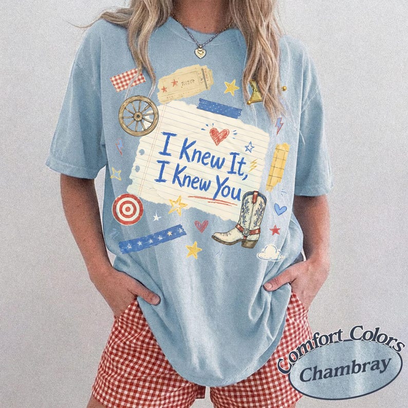 Puede incluir: Una camiseta de manga corta azul claro con un gr&aacute;fico de papel de cuaderno rayado con el texto I Knew It, I Knew You. El dise&ntilde;o incluye una bota de vaquero, una rueda de carreta, una diana, estrellas, corazones y cintas decorativas.