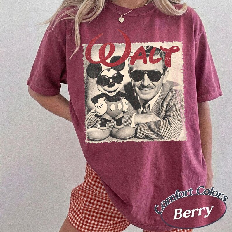 May include: Berry-colored t-shirt featuring a vintage-style graphic of Mickey Mouse and Walt Disney wearing sunglasses. The word "WALT" is printed above the image. The shirt has a relaxed fit and the words "Comfort Colors" and "Berry" are printed on the bottom.