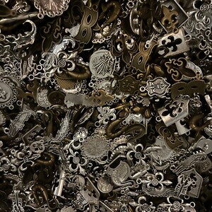 May include: A large pile of silver and bronze metal charms, including fleur-de-lis, anchors, and other decorative designs.