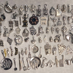 May include: A collection of silver-toned metal charms featuring various kitchen and food-related designs. The charms include a variety of utensils, food items, and other kitchen-related objects.