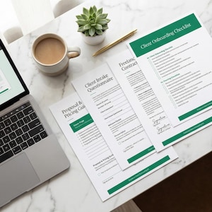 May include: A laptop, documents, and a coffee cup are arranged on a marble surface. The laptop displays a document with green accents. Several printed documents include "Client Onboarding Checklist" and "Freelance Contract" text.