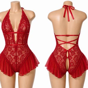 May include: Red lace bodysuit with a halter neck and a deep V-neckline. The lingerie features a floral lace pattern, a ribbon detail, and a ruffled hem. The back has a crisscross ribbon design and a keyhole opening.