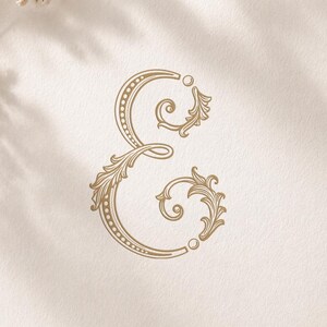 Può includere: Un cartoncino quadrato bianco con un simbolo ampersand dorato e ornato al centro. Il testo MONOGRAM è stampato in alto e Monograms Logos Alwih è stampato in basso. Il cartoncino è decorato con piccoli fiori bianchi e un nastro.