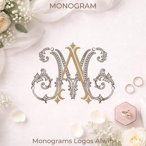May include: Elegant monogram design featuring the letters "A" and "G" in gold and gray, surrounded by ornate floral embellishments. The image includes wedding rings, a ring box, and white flowers, suggesting a wedding theme. Text at the top reads "MONOGRAM".