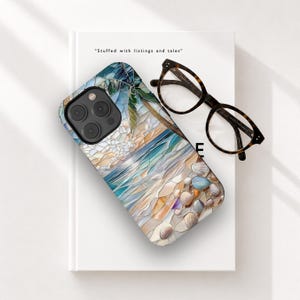 May include: A smartphone case featuring a stained-glass style beach scene with blue ocean waves, sandy shores, and scattered seashells. The case is placed on a white book with the text "Stuffed with listings and tales" and black glasses.