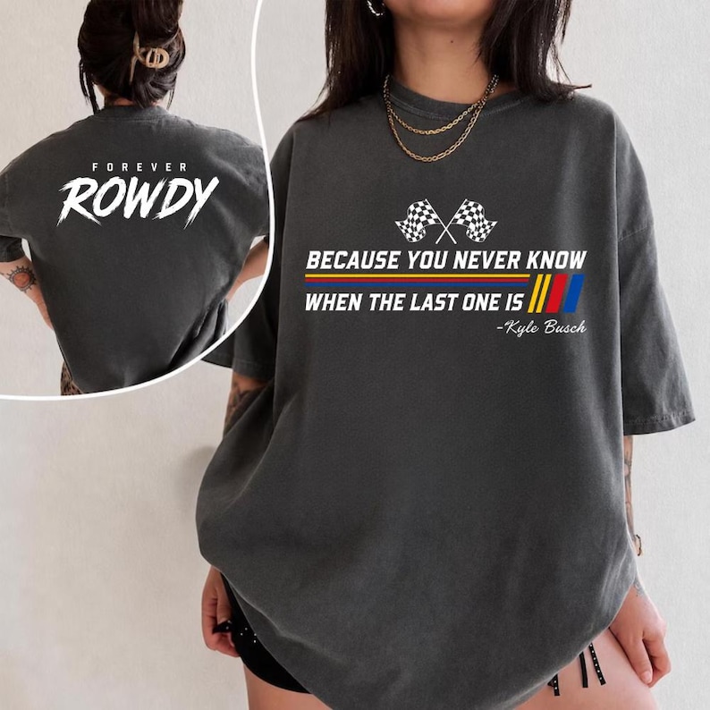 May include: Dark gray t-shirt with the text "FOREVER ROWDY" on the back and "BECAUSE YOU NEVER KNOW WHEN THE LAST ONE IS" with checkered flags and the name "Kyle Busch" on the front. The shirt has a vintage, worn look.