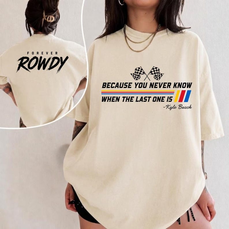 May include: Cream-colored t-shirt with the text "FOREVER ROWDY" on the back and "BECAUSE YOU NEVER KNOW WHEN THE LAST ONE IS" with checkered flags and stripes on the front. The shirt also has the text "-Kyle Busch".