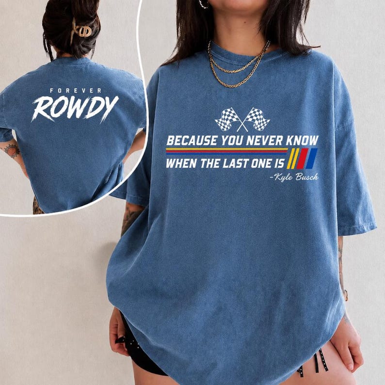 May include: Blue t-shirt with the text "FOREVER ROWDY" on the back and "BECAUSE YOU NEVER KNOW WHEN THE LAST ONE IS" with checkered flags and stripes on the front. The shirt also includes the name "-Kyle Busch".