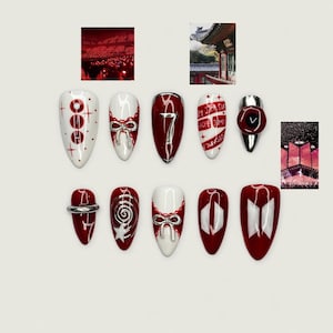 May include: A set of red and white nail art designs. The designs include bows, the number 7, and text. Some nails have silver accents. The overall theme is a bold and artistic nail design, perfect for a special occasion.