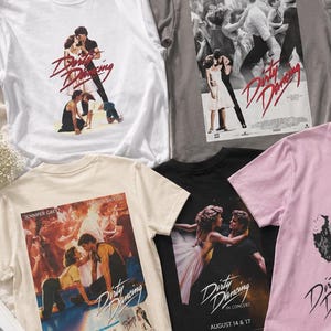 Könnte beinhalten: Eine Sammlung von acht kurzärmeligen T-Shirts in verschiedenen Farben wie Weiß, Grau, Blau, Schwarz, Creme und Rosa. Jedes T-Shirt zeigt einen Grafikdruck zum Film Dirty Dancing mit Szenen von Tänzern und dem Filmtitel als Text.