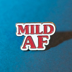 May include: A red and white enamel pin with the text "MILD AF" in white letters with a red outline.