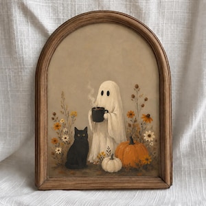 Op de afbeelding: Een boogvormige houten lijst met een schilderij van een witte geest die een dampende zwarte mok vasthoudt, een zwarte kat ernaast, en oranje en witte pompoenen omringd door gele en witte wilde bloemen tegen een gedempte beige achtergrond.