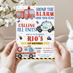 May include: A birthday invitation featuring illustrations of a red fire truck, a police car, and an ambulance. The invitation includes the text "SOUND THE ALARM, GRAB YOUR GEAR" and "CALLING ALL UNITS" with details for Rio's 1st birthday.