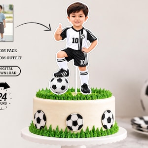 May include: A custom cake topper featuring a child in a black and white football uniform with the number 10, giving a thumbs up while standing on a football. The topper is displayed on a round cake decorated with green icing and footballs.