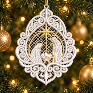 May include: A white and gold embroidered lace ornament featuring a nativity scene with figures of Mary, Joseph, and the infant Jesus under a star. The design is enclosed in an intricate, swirling filigree frame with a hanging loop.
