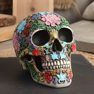 Pode incluir: Uma figura decorativa de crânio com padrões florais e de volutas intrincados e em relevo em tons vibrantes de rosa, azul, verde, vermelho e amarelo sobre uma base neutra, com órbitas oculares pretas profundas e dentes detalhados.