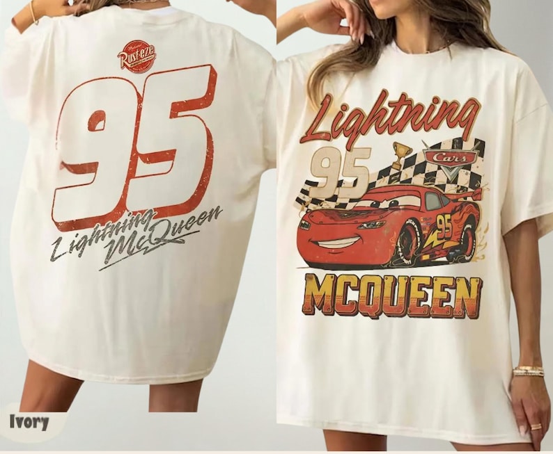 May include: An ivory t-shirt featuring a graphic of the red race car Lightning McQueen from the movie Cars. The front displays the car, a checkered flag, and the text Lightning McQueen. The back shows the number 95 and the text Lightning McQueen.