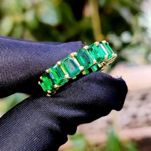 Aliança de casamento com esmeralda verde sintética lapidada em corte esmeralda, banhada a ouro amarelo 14K, prata 925.