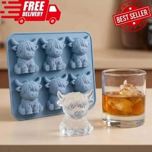 Könnte beinhalten: Eine blaue Silikon-Eiswürfelform mit sechs Highland-Kuh-Formen. Vor der Form befindet sich eine klare Eisskulptur einer Highland-Kuh. Rechts ein Glas mit bernsteinfarbener Flüssigkeit und einem Highland-Kuh-Eiswürfel. Der Text "FREE DELIVERY" und "BEST SELLER".