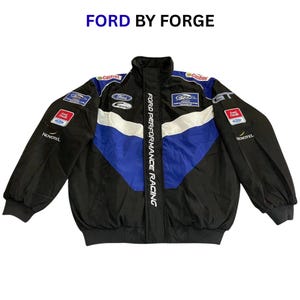 Op de afbeelding: Zwarte en blauwe racejas met witte accenten en meerdere sponsorpatches. De jas heeft de tekst "FORD PERFORMANCE RACING" en het Ford-logo. De tekst "FORD BY FORGE" staat bovenaan de afbeelding.