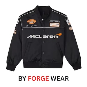 May include: Black racing jacket with white accents and multiple patches. The jacket features the McLaren logo in white and orange, and the text "FORMULA 1 RACING". The text "BY FORGE WEAR" is at the bottom.