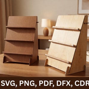 Peut inclure: Deux présentoirs en bois avec trois étagères chacun. L'un est brun foncé, l'autre est beige clair. Les présentoirs sont inclinés et de conception minimaliste. Le texte "SVG, PNG, PDF, DFX, CDR" est en bas de l'image.