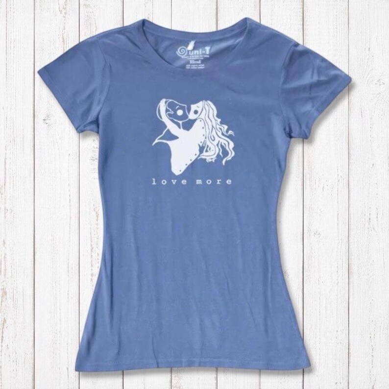 Sky blue bamboo & organic cotton Love More T-Shirt for women with white heart graphic. Sustainable and romantic fashion statement.