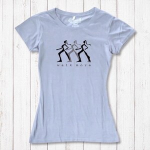 Light blue Women's Walking T-Shirt in Bamboo & Organic Cotton with black 'Walk More' silhouette design. Comfortable and eco-friendly top.