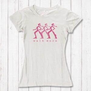 Women's Walking T-Shirt in Bamboo & Organic Cotton in off-white with pink 'Walk More' graphic. Sustainable fitness tee for hikers and walkers.