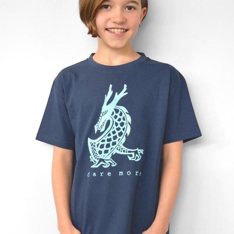 Child wearing a navy blue Uni-T organic cotton t-shirt featuring a light blue hand-illustrated dragon graphic
