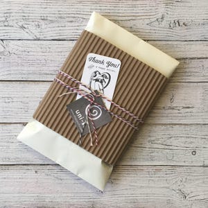 Eco-friendly gift packaging for Uni-T Kids' Organic Cotton Dragon T-Shirt, wrapped in kraft paper with thank-you tag and twine.
