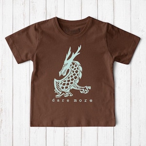 Uni-T kids brown organic cotton t-shirt featuring a light blue hand-illustrated dragon graphic and Dare More text