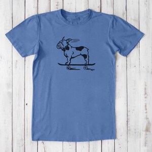 May include: A light blue t-shirt with a black and white illustration of a bulldog riding a skateboard. The bulldog is wearing a collar and has a tongue sticking out. The skateboard has four wheels.
