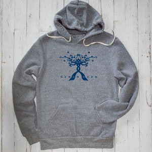 May include: A gray hooded sweatshirt with a blue graphic of a tree with the text "dream more" underneath.