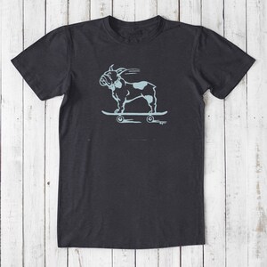 May include: A dark grey t-shirt with a light blue graphic of a French bulldog skateboarding. The graphic is in a vintage style.