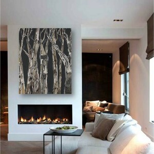 May include: A black and white abstract painting of trees with a textured, brushstroke effect. The painting is hanging above a fireplace in a modern living room.
