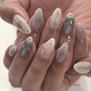 Ongles à presser amandes : dégradé crème, paillettes dorées, motif céleste (gel réutilisable)