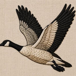 Op de afbeelding: Geborduurd kunstwerk van een Canadese gans in vlucht. De gans heeft zwarte, witte en bruine draaddetails, met uitgestrekte vleugels tegen een neutrale linnen achtergrond. De kop van de vogel is zwart met een witte wangvlek.