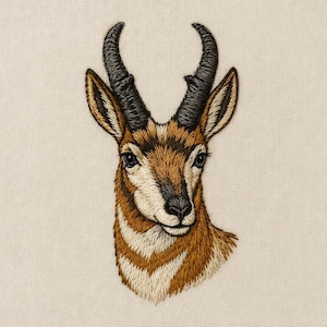 Può includere: Ritratto ricamato di una testa di antilope americana. L'opera presenta cuciture dettagliate nei toni del marrone, beige e nero, con uno sfondo color crema. L'antilope ha grandi occhi scuri e corna ricurve.