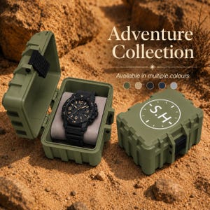 May include: A black analogue wristwatch with a textured strap and a round face featuring numerical markers, displayed inside an open olive green hard-shell storage case. A closed matching case features a circular logo with the letters S.H.