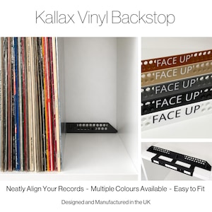 以下が含まれることがあります： Kallax Vinyl Backstopは、ハニカム模様と前面に「FACE UP」の文字が印刷された黒い長方形の棚用インサートです。白い棚ユニットに設置され、レコードの列の後ろに配置されています。また、他の色のバリエーションも表示されています。