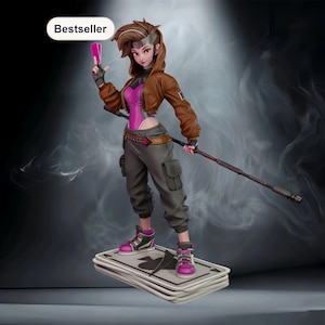 May include: A figurine of a character in a brown jacket, pink bodysuit, and gray pants, holding playing cards and a staff. The figure stands on a stack of playing cards. The word "Bestseller" is in a white oval in the upper left corner.