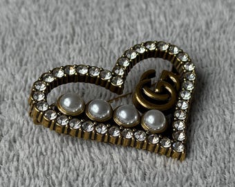Broche GG artesanal reciclado com pérola dourada em formato de coração.