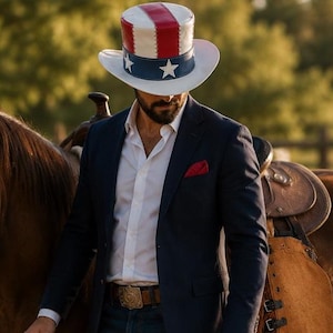Puede incluir: Un sombrero de copa con un diseño patriótico en rojo, blanco y azul con estrellas blancas sobre una banda azul, combinado con una camisa blanca, un blazer azul marino, un pañuelo de bolsillo rojo y un cinturón de cuero marrón con hebilla.