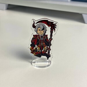 K&ouml;nnte beinhalten: Eine transparente Acrylfigur eines Charakters mit wei&szlig;em Haar, der ein rot-schwarzes Outfit tr&auml;gt und eine rote Sense h&auml;lt. Die Figur steht auf einem transparenten Sockel.