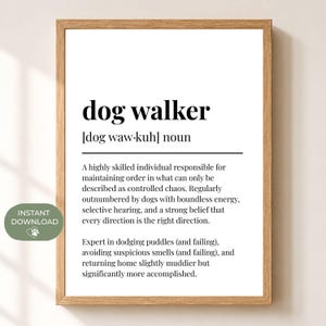 以下が含まれることがあります： dog walkerという言葉を辞書風に定義した、額縁入りのウォールアートプリント。白い背景に黒い文字で印刷されており、明るい色の木製フレームに収められています。この定義は、犬の散歩代行者の役割をユーモラスに説明しています。