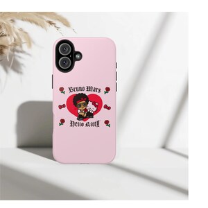 Puede incluir: Funda de tel&eacute;fono rosa claro con un gr&aacute;fico de dibujos animados de Bruno Mars y Hello Kitty. El dise&ntilde;o incluye un coraz&oacute;n rojo, rosas y el texto "Bruno Mars" y "Hello Kitty" en una fuente decorativa. La funda tiene un recorte para c&aacute;mara de doble lente.